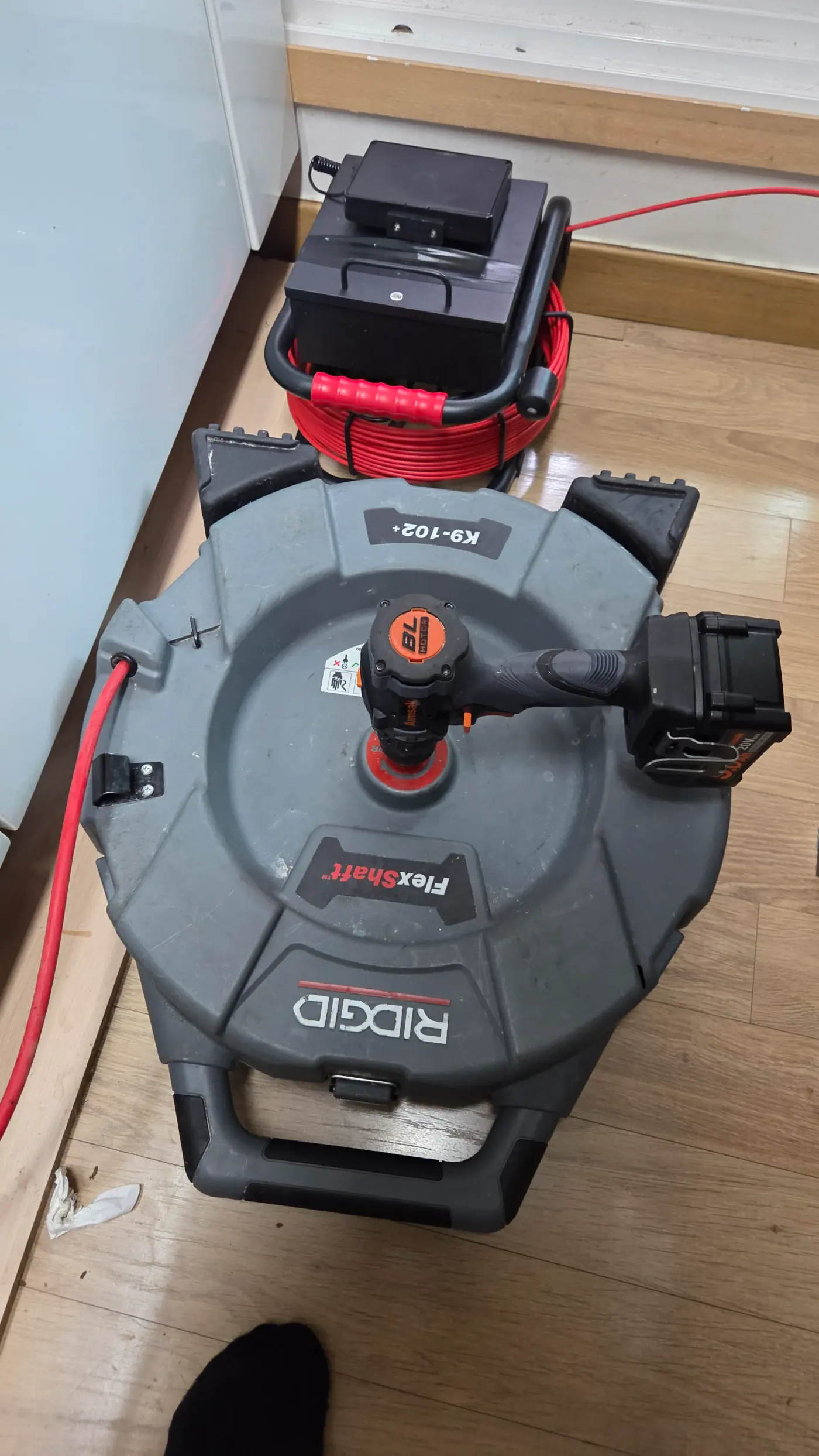 RIDGID K9-102+ 플렉스 샤프트 장비를 가동하여 막힌 주방 하수구 기름때를 분쇄하는 모습